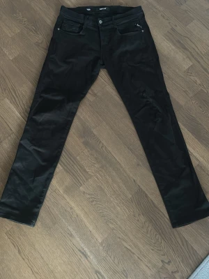 Replay jeans hyperflex - Säljer ett par svarta replay jeans med slimfit passform och klassisk femficksdesign. Jeansen har smal passform och är tillverkade i ett stretchigt material för extra komfort. Perfekta till en avslappnad eller trendig look.                    Storlek: W31 L30