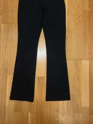 Svarta bootcut leggings - Säljer ett par svarta leggings med bootcut-modell. De har hög midja och är tillverkade i ett stretchigt material som sitter skönt på kroppen. Perfekta för dig som gillar en enkel men trendig look.