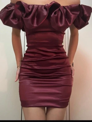 Vinröd offshoulder kort klänning - Supersnygg vinröd kort klänning i glansigt satinliknande material. 