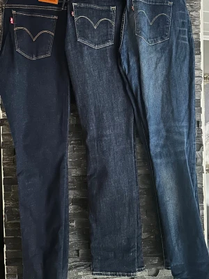 Levi's Super Skinny jeans,  - Slumpar bort Tre par Levi's Super Skinny jeans i olika blå tvättar. Klassisk femficksmodell med smal passform och hög midja. Snygga kontrastsömmar och ikoniska Levi's-detaljer på bakfickorna. Perfekta för dig som gillar en tight siluett och tidlös denimstil.