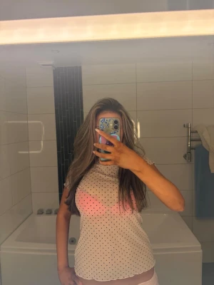 Vit prickig mesh topp - Säljer en söt vit mesh topp med små svarta prickar. Toppen är lätt transparent och är från Even and odd.