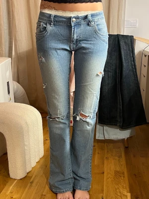 Ljusblå slitna bootcut jeans - Säljer ett par ljusblå bootcut jeans. Midja ca 40, innerbenslängd ca 80-82. Jag är 168 med långa ben! Har inget måttband så uppskattar måtten. Skulle säga storlek M/38