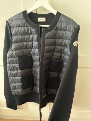 Moncler höstjacka - Säljer min jacka i storlek L men sitter bättte på en M då den är mindre i storlek. Kommer med dust bag. En perfekt jacka till höst och vår. Kvitto finns. Ingen tecken på användning!
