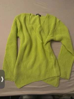 Limegrön stickad tröja från Boohoo - Säljer en limegrön stickad tröja från Boohoo Tall i storlek S. Tröjan har en djup omlott-ringning, lång ärm och ribbstickad struktur. Perfekt för dig som gillar färg och vill sticka ut lite extra. Materialet känns mjukt och stretchigt.