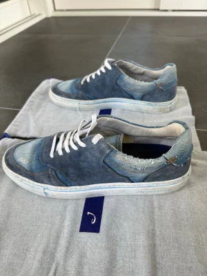 Blå denim sneakers från Jacob Cohen - Tja! Säljer denna unika skor i blå denim från Jacob Cohen med slitna detaljer och vita skosnören. Perfekta för dig som gillar en avslappnad och trendig stil. Sjukt häftiga och svåra att få tag på! | Storlek: 43 | Skick: 8,5/10 | Meddela gärna vid eventuella frågor! Mvh ResellGarms 