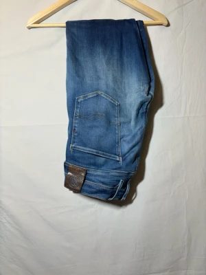 Blå jeans med raka ben - Snygga blå jeans med raka ben och klassiska bakfickor med dekorativa sömmar. Jeansen har en brun läderpatch vid linningen och är tillverkade i denim. Perfekta för en avslappnad och trendig stil. Pris kan diskuteras 