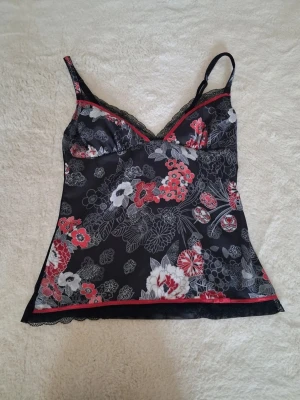 Blommig topp - En blommig topp i mesh/satin material!