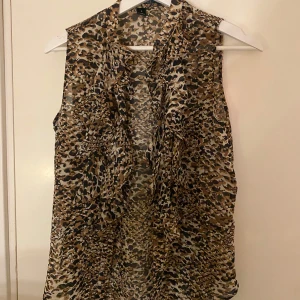 Leopardmönstrad tunn väst från Lauren - Snygg leopardmönstrad väst från Ralph Lauren i polyester. Perfekt för att ge piff till en simpel outfit. Västen har en klassisk passform och är lätt att matcha med olika stilar. Stl S/M