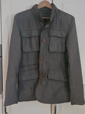 Massimo Dutti jacka  - Tjena, säljer nu denna riktigt feta Massimo dutti feildjacket i bra skick. Är lite smutsig längsmed ner på högersidan  och har en fläck någonstans på högersidan men inget som syns vi användning och inget man tänker på. Jackan skiftar färg lite beroende på ifall det är mörkt eller ljust ute är det ljust är den mer grön medans ifall det är mer mörkt ute är den mer grå. 8/10 skick! Fråga gärna ifall ni har någon fråga! Mvh Vilgot 