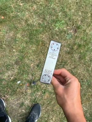 Scotty Cameron Studio Select Newport 2 by Titleist säljes. - Scotty Cameron Studio Select Newport 2 by Titleist säljes.  Klassisk premiumputter i bra skick med normalt bruksslitage. Utrustad med SuperStroke-grepp som ger en stabil och bekväm känsla på greenerna.  Puttern är väl omhändertagen och har fortfarande mycket spel kvar. En av Scotty Camerons mest populära modeller tack vare sin känsla, balans och tidlösa design. Inget headcover tillkommer  Pris: 2545 kr eller bud. Pris kan diskuteras  Fråga gärna!!!