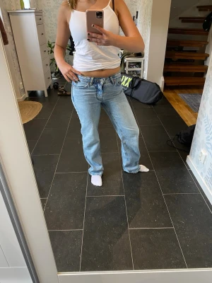 Ljusblå raka jeans - Säljer ett par ljusblå jeans med rak passform och klassisk femficksdesign. Jeansen har normalhög midja och är i ett mjukt denimtyg som ger en avslappnad look. Perfekta till vardags för en chill och trendig stil. Knappt använda. 
