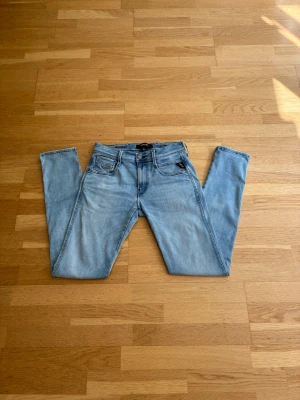 replay anbass Hyperflex - Säljer ett par ljusblå slim fit jeans med klassisk femficksdesign och dragkedjegylf. Jeansen har raka ben och subtila slitningar för en avslappnad look. Perfekta till vardagsstilen och passar till det mesta i garderoben.