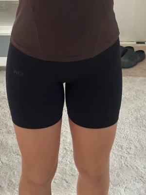 Svarta träningsshorts från ICIW - Säljer ett par svarta träningsshorts från ICIW. De är tighta, stretchiga och har en midjehög passform som sitter skönt vid träning eller till vardags. Shortsen har en scrunch där bak som framhäver rumpan. Materialet är mjukt och följsamt, perfekt för gymmet eller löprundan. Skriv vid frågor eller funderingar💕