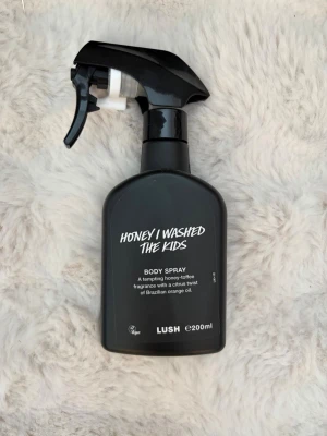 Honey I Washed The Kids Lush - Body spray från Lush i doften Honey I Washed The Kids. Flaskan är svart med spraymunstycke och rymmer 200 ml. Doften är söt med toner av honung och kola samt en fräsch citrus-twist från brasiliansk apelsinolja. Perfekt för dig som gillar unika och söta parfymer.