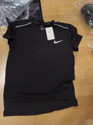 Svart träningsset från Nike - Svart träningsset med t-shirt och matchande shorts. Båda plaggen har en reflekterande logga och är tillverkade i ett lätt, snabbtorkande material som passar perfekt för löpning eller gym. Pris går att diskutera vid snabb affär 