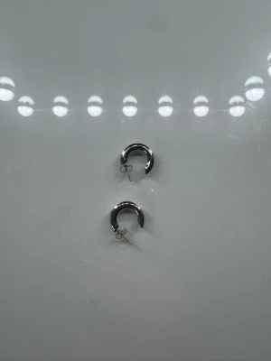 Chunky silverfärgade hoops örhängen - Säljer ett par chunky hoops örhängen i silverfärgad metall. De har en rund, tjock form och stängs med klassisk nål och plopp. Perfekta för dig som gillar stilrena och trendiga accessoarer.
