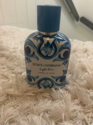 Dolce & Gabbana Light Blue Capri - Dolce & Gabbana Light Blue Capri In Love parfym med en unik blå och vit dekorativ flaska. Flaskan har ett konstnärligt mönster inspirerat av medelhavet och ett blått lock. Perfekt för dig som gillar exklusiva och fräscha dofter.