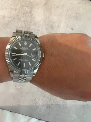 41mm silver klocka 904L - Stilren klocka. Klockan har klassisk räfflad bezel och datumfönster vid klockan tre. Perfekt accessoar för dig som gillar tidlös design och exklusiv känsla.