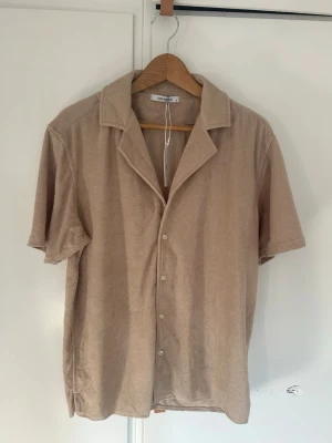 Kortärmad frottéskjorta John Henric - Ny med prislapp! Beige kortärmad skjorta i frotté från John Henric. Storlek M