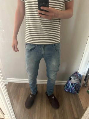 Ljusblå replay anbass - Säljer ett par ljusblå replay anbass jeans med en washed look och raka ben. Bredden är 28 och längden är 105 cm! Jeansen är i bra skick och bara blivit använda ett fåtal gånger 