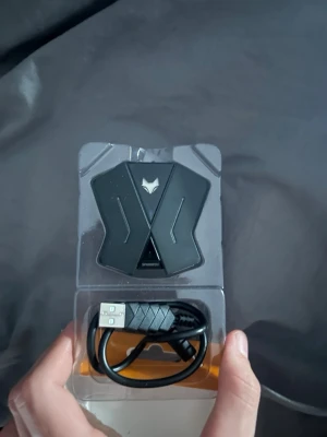 Sparkfox adapter för handkontroller - Säljer en svart Sparkfox adapter för handkontroller, perfekt för att koppla tangentbord och mus till din konsol. Kommer med USB-kabel och har en modern, kantig design med vit logga på framsidan. Passar till PS4, PS5 och Xbox enligt förpackningen.