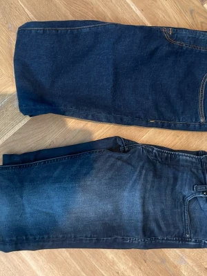 Två stycken Mörkblåa skinny jeans - Säljer ett par mörkblå skinny jeans med smal passform som är gjorda i stretchigt denimtyg. Båda jeansen är W31 L 34. Den andra bilden är Jack & jones i modellen skinny liam. Dressman jeansen på den tredje bilden är slim fit. Kom med prisförslag🙌