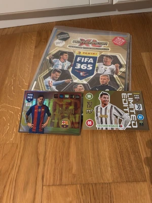 FIFA 365 samlaralbum med fotbollskort - Säljer ett Panini FIFA 365 samlaralbum med massor av fotbollskort, inklusive limited edition-kort på Messi och Ronaldo. Perfekt för dig som gillar att samla på fotbollsstjärnor och vill ha ett komplett album med olika spelare och lag.