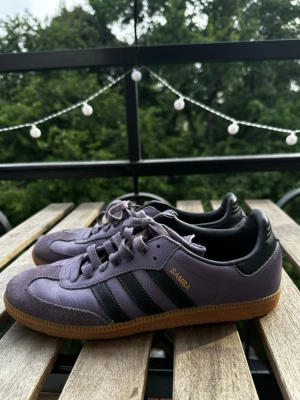 Nyskick Lila Adidas Samba sneakers - Säljer ett par lila Adidas Samba sneakers. Skorna är knappt använda sedan köp och har inga skav alls. De är enbart ingångna. Skorna är sann till storleken men funkar även för någon med storlek 43. Kvitto och box saknas men försäkrar om att de är äkta. 