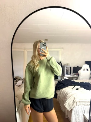 Ljusgrön oversized hoodie - Säljer en ljusgrön oversized hoodie i mjukt material. Hoodien har en enkel design utan tryck eller logga, rund halsringning och långa ärmar. Perfekt för en chill och avslappnad stil. Nopprig på undersrmarna! 