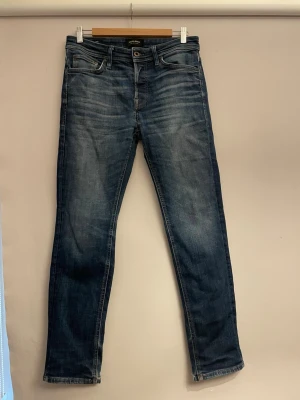 Mörkblå raka jeans - Snygga mörkblå jeans med raka ben och klassisk femficksmodell. Jeansen har subtila slitningar framtill och bakfickor utan dekorationer. Tillverkade i denim med en autentisk tvätt för en avslappnad look.