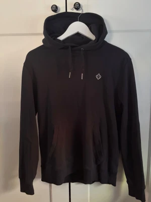 Svart hoodie från Morris - Svart hoodie från morris 10/10 skick. Inga missfärgningar utan det är ljuset som påverkar färgen. Storlek medium men passar även S. Kontakta mig om du har några frågor eller funderingar 