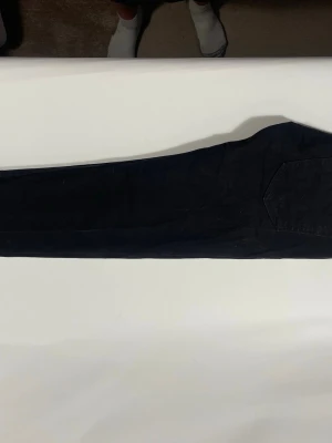 Svarta Levi's slim fit jeans - Säljer ett par svarta slim fit jeans från Levi's med klassisk femficksdesign och rakt ben. Jeansen har en diskret röd Levi's-tag på bakfickan och patch med logga i midjan. Perfekta för en clean och stilren look.W 28 L30