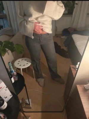 Grå raka jeans med medel hög midja - Säljer ett par grå jeans med rak passform och medel hög midja. Jeansen har klassisk femficksdesign och bälteshällor. Materialet är denim i bomull och de har en tidlös look som passar till det mesta.