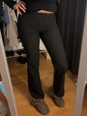 Svarta kostymbyxor  - Säljer ett par svarta bootcut byxor med normal passform och midja. Byxorna har en enkel design utan synliga detaljer och är perfekta för en clean och stilren look. 