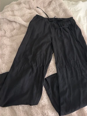 Svarta vida linnebyxor - Snygga svarta linnebyxor med avslappnad passform. Byxorna har raka, vida ben och är tillverkade i ett lätt och luftigt linnematerial. Perfekta för en chill och stilren look.