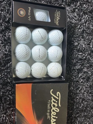Titleist Pro V1 golfbollar - Säljer ett set med vita Titleist Pro V1 golfbollar i originalförpackning. Bollarna har klassisk dimple-yta och levereras i en snygg svart och orange låda. Perfekt för dig som vill ha riktigt bra golfbollar till nästa runda.