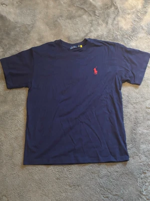 Polo Ralph Lauren T-shirt - Denna Ralph lauren mörkblåa T-shirt är köpt i USA och är helt ny med tags. Inga defekter. Storlek L. T-shirten är unisex.