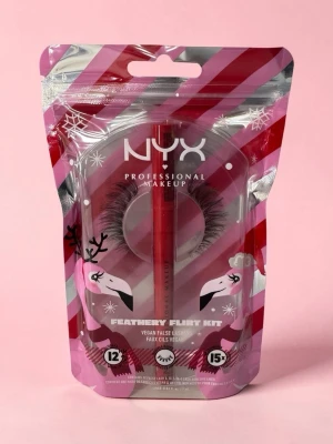 NYX  ögonfransar  - NYX Professional Makeup Feathery Flirt Kit innehåller veganska lösögonfransar och ett rött franslim. Förpackningen är rosa med silverdetaljer och har ett lekfullt vintertema med renmotiv. Perfekt för att ge fransarna extra volym och längd.
