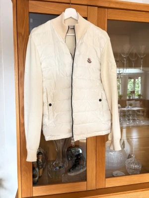 Cardigan från Moncler - Vit cardigan från moncler, krämvit i färgen. Tryck på bröst och armen. Har kvar påse+lappar ❤️pris kan diskuteras! Perfekt till hösten, använt max 6 gånger 