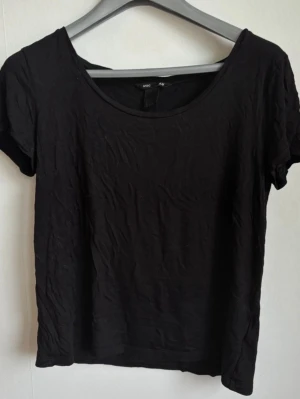Svart t-shirt från H&M Basic (Stl S) - Klassisk svart kortärmad t-shirt från H&M Basic. Modellen har en fin, lite djupare rundad urringning (scoop neck) och ett mjukt fall  Märke: H&M Basic  Storlek: S (EUR S / US S)  Färg: Svart  Skick: Fint använt skick (behöver bara strykas lite)   Kommer från ett djur- och rökfritt hem. Fraktas snabbt! ✨ 