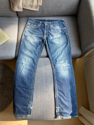 True Religion Jeans Straight - True religion jeans, straight, storlek 34, bra skick, med slitningar, midja 43cm, längd 113cm, innerben 83cm och benöpppning 23cm.