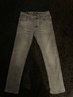 Jack & Jones jeans, W30 - Säljer ett par fina grå/svarta slim jeans från Jack and Jones i modellen Glenn. Jeansen är i bra skick med en fin tvätt.                                             Storlek: W30 L30.                                                                 Skickar inom 24h efter köp✅hör av er vid frågor!