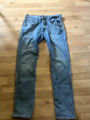 Replay anbass - Säljer ett par ljusblå jeans med rak passform och klassisk femficksdesign. Jeansen har normal midja och är tillverkade i denim. Perfekta för en avslappnad och stilren look.