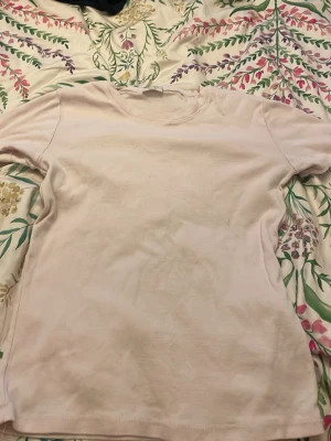 Ljusrosa t-shirt från brandy Melville  - En basic ljusrosa t-shirt från brandy Melville med rund hals och korta ärmar. Tillverkad i mjuk bomull som känns skön mot huden. Perfekt att matcha med jeans eller kjol för en enkel och clean look.