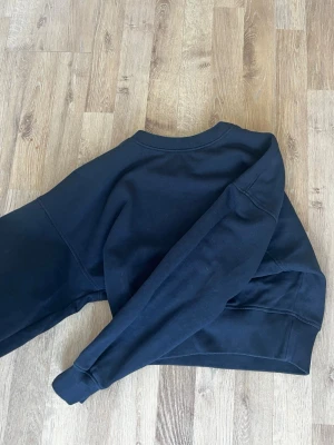 Mörkblå sweatshirt från Gina Tricot - En enkel och stilren mörkblå sweatshirt i mjukt bomullsmaterial. Tröjan har rund halsringning, långa ärmar och ribbade muddar vid ärmslut och nederkant. Perfekt för en avslappnad och clean look💓