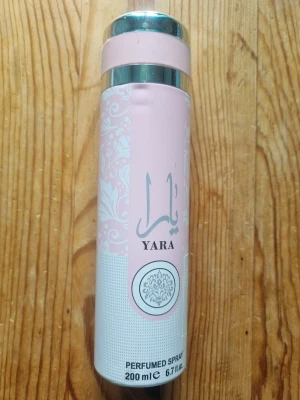 Yara parfym spray 200 ml - Säljer en Yara parfym spray i en snygg cylinderformad flaska på 200 ml. Flaskan är ljusrosa och vit med silverdetaljer och orientaliskt mönster. Perfekt för dig som gillar fräscha och feminina dofter.