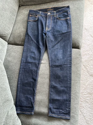 Raw Denim Nudie, Slim fit - Ett par slim fit jeans från nudie i storleken 31/32 men skulle säga att dom sitter mer likt 30/30. Nästan helt nya och använda endast ett fåtal gånger. Bara fråga om bilder eller annat vid behov🤝