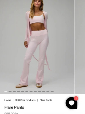 Ljusrosa set med flarebyxor och topp - Säljer ett ljusrosa set med utsvängda byxor och matchande crop top i mjukt stretchigt material. Toppen är i D och byxorna är i storlek S/Short och passar bra i längden på mig som är 164.