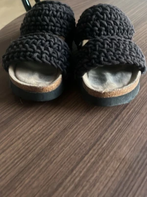 Svarta stickade sandaler - Säljer ett par svarta sandaler med två breda stickade band över foten. Storlek 37, från din sko. ny pris 550kr. hör av er vid frågor! pris kan diskuteras vid snabba köp