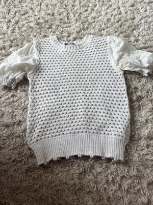 Vit stickad topp med puffärmar - Söt vit stickad sommar topp med hålmönster och korta puffärmar i broderad bomull. Toppen är från Zara och i Stl S, säljer för den har blivit förliten! Tröjan har använts få gånger!
